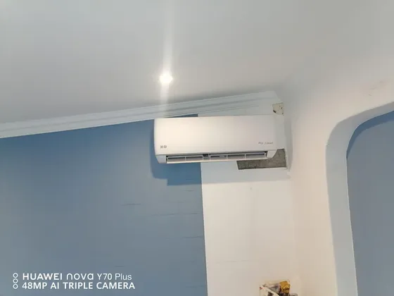 An indoor unit fitted high on a two-tone wall beneath the ceiling cornice.