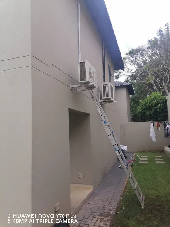 A wider view of the wall-mounted outdoor units and their pipe routes.