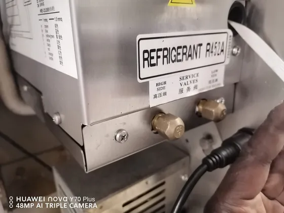 A close-up of refrigerant service connections on an air-conditioning unit.