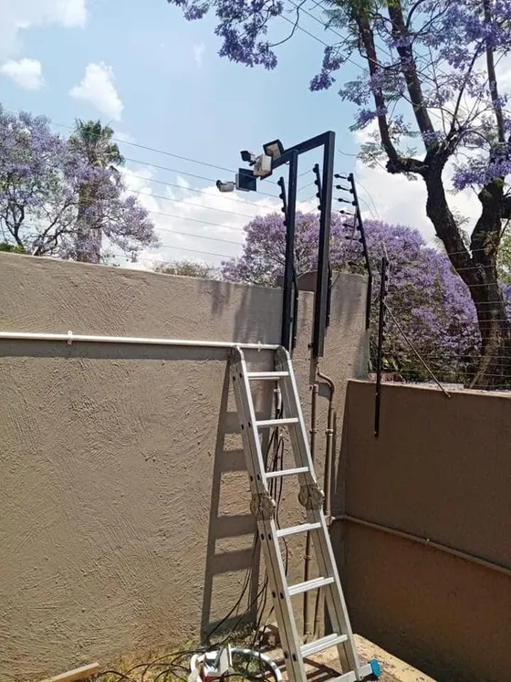 An installation ladder beside the camera mounting structure at the boundary wall.