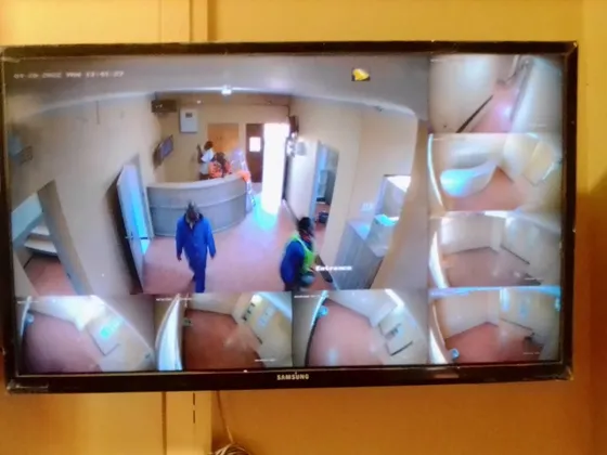 An entrance camera feed and supporting views displayed on a wall-mounted monitor.