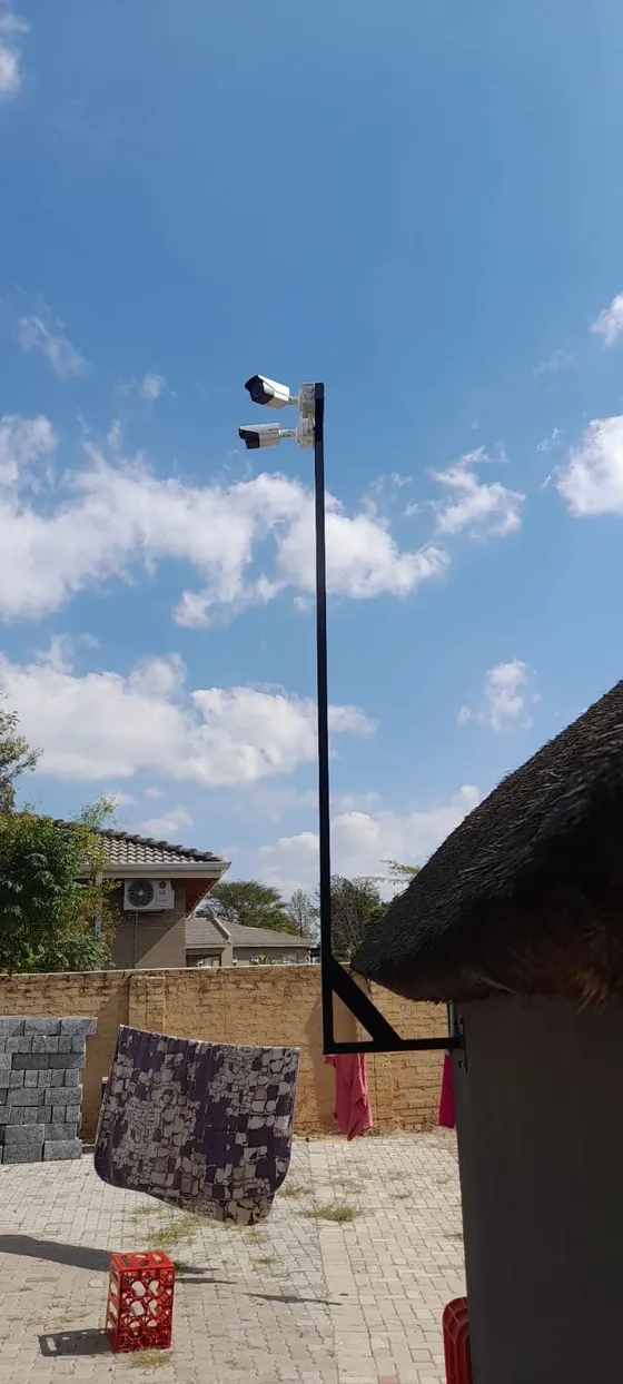 An elevated camera pole overlooking the property entrance and boundary.