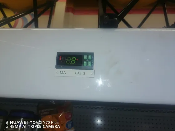 A digital temperature display mounted above a cooling-room entrance.