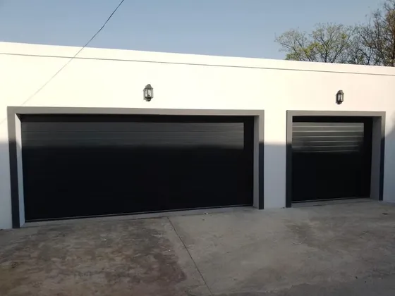 Matching black double and single garage doors across a white frontage.