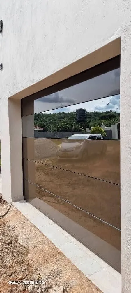 A close angled view of a reflective garage door with a wide horizontal glazed panel.