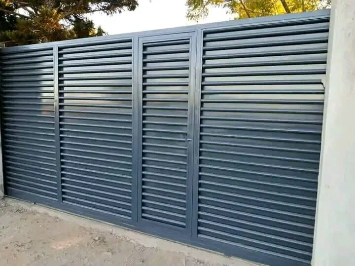 A grey driveway gate with closely spaced horizontal slats and matching framed panels.