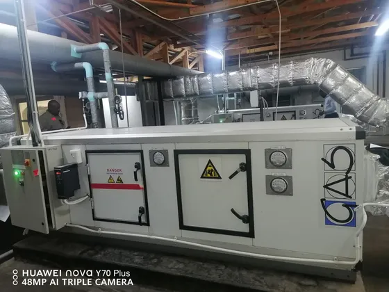 Large air-handling equipment with insulated ductwork, pipe runs and filter gauges.