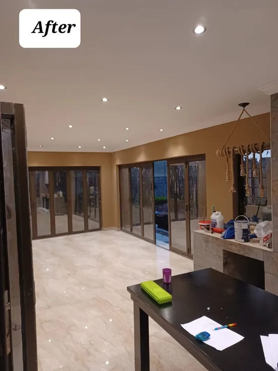 An interior view of the tiled floor, recessed lighting and glazing.