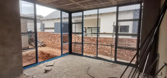 Corner glazing and door frames viewed from inside a building under construction.