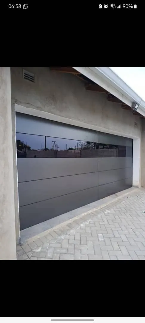 A wide sectional garage door with a dark horizontal glazed panel.