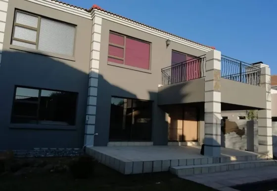 A two-storey property with contrasting exterior wall finishes and a balcony.