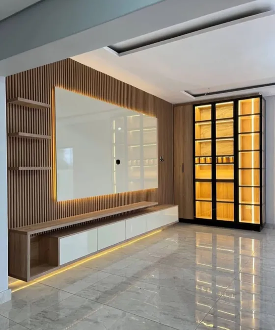 An illuminated wall display with a floating cabinet and glass-fronted storage.