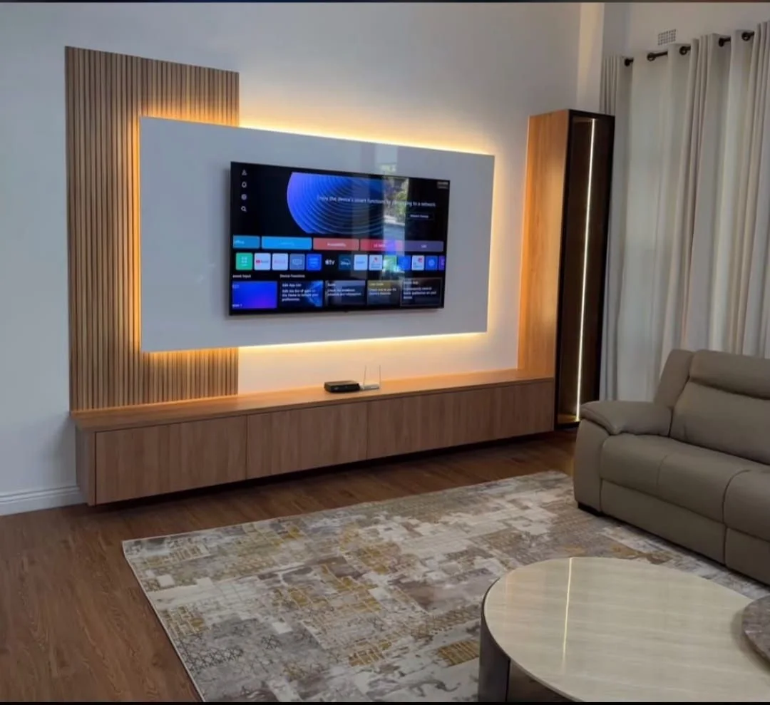 Warm living space with a backlit television wall and fitted timber storage