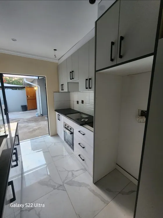 Fitted cupboards, open shelving and a tall appliance recess.