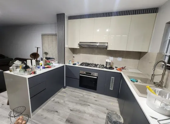 Dark base cupboards and pale wall cabinets around an L-shaped worktop.